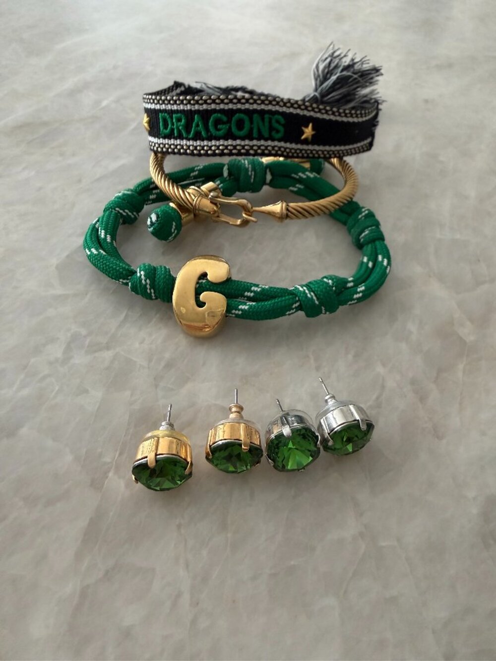 Green and gold stack of bracelets and stud earrings